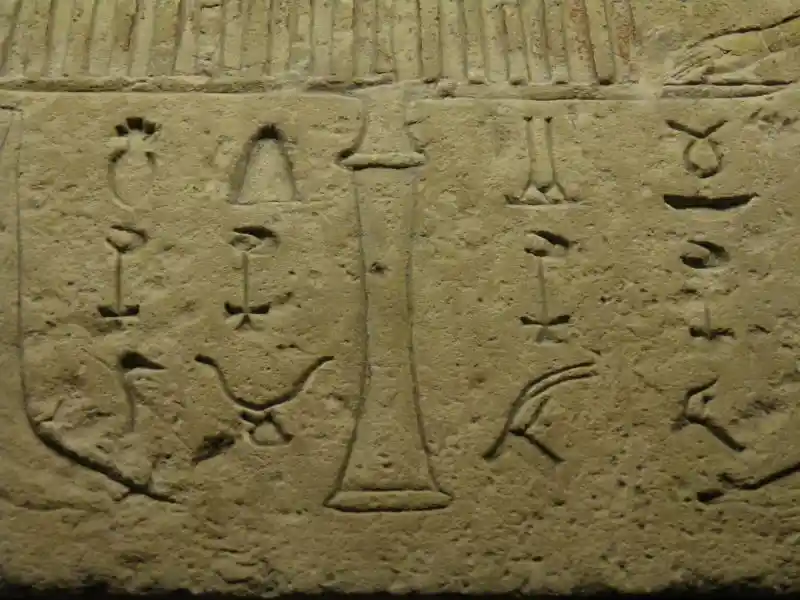 Four-point cross, crescent, triangle, deer head and other symbols on the false door of Tjetji and Debet